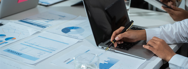 man sitting at desk working, looking at charts